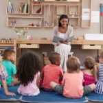 Teacher At Montessori School Reading To Children